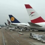 Airplanes parked at Dulles Airport with visible airline logos on a cloudy day.